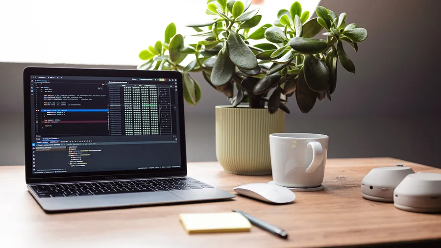 Portátil con código y herramientas de inteligencia artificial en una mesa de trabajo