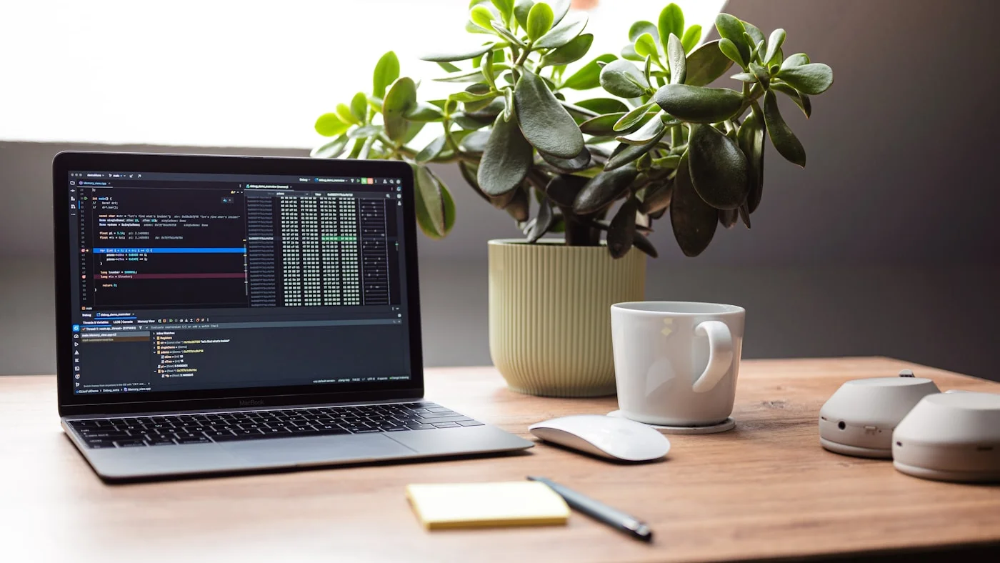 Portátil con código y herramientas de inteligencia artificial en una mesa de trabajo