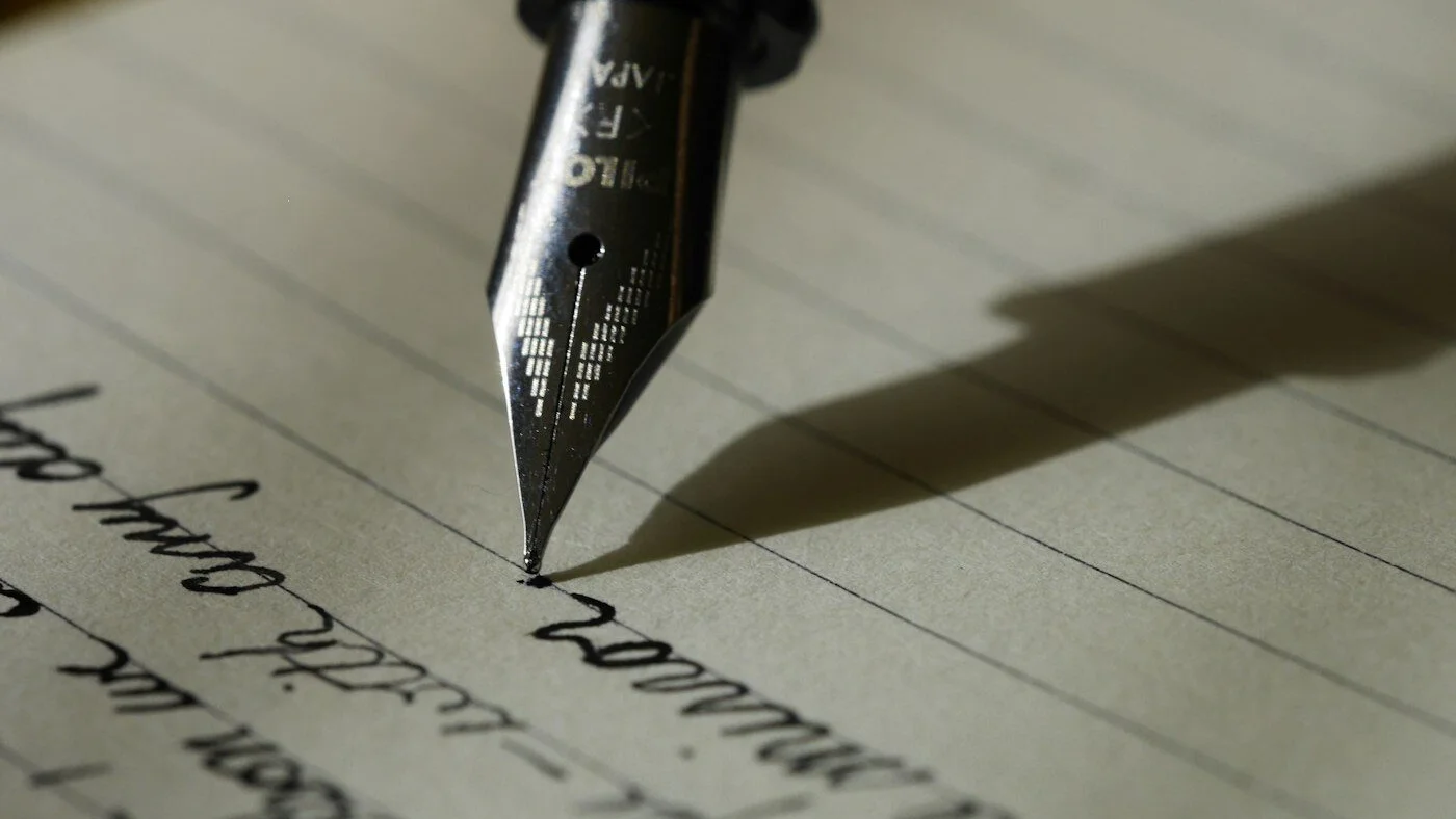 Persona escribiendo una idea de contenido junto a un portátil
